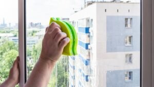 Person using magnetic window cleaners on a high-rise apartment window for streak-free glass cleaning
